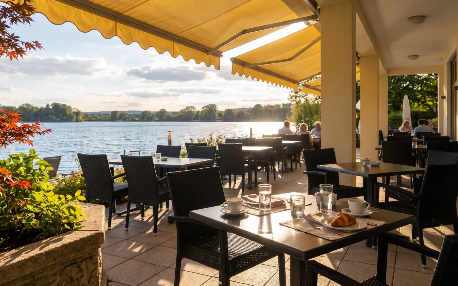 Lebendige Seehaus-Terrasse mit Blick aufs Wasser.